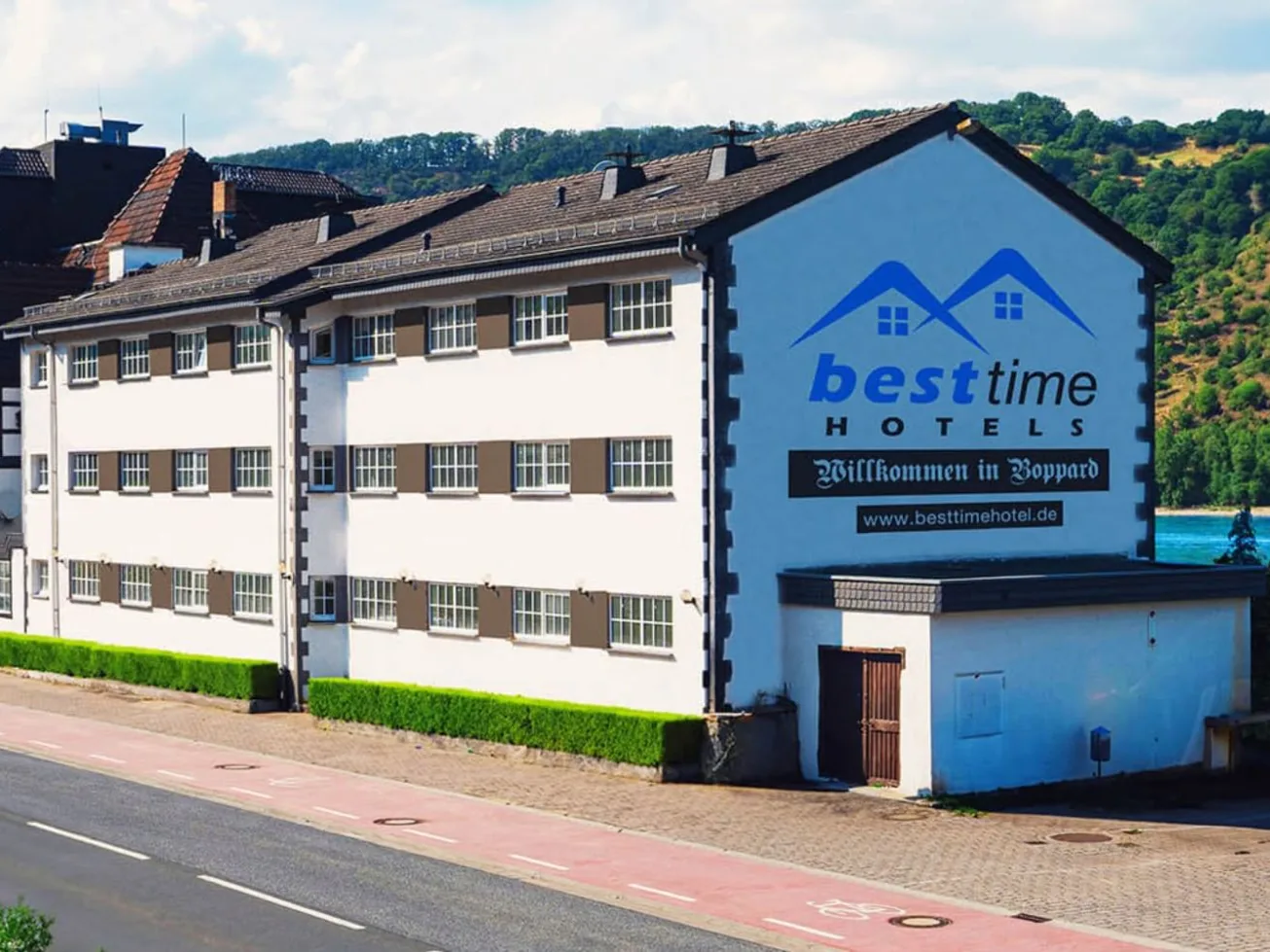besttime Hotel in Boppard: langgestrecktes weißes Hotelgebäude direkt am Rhein